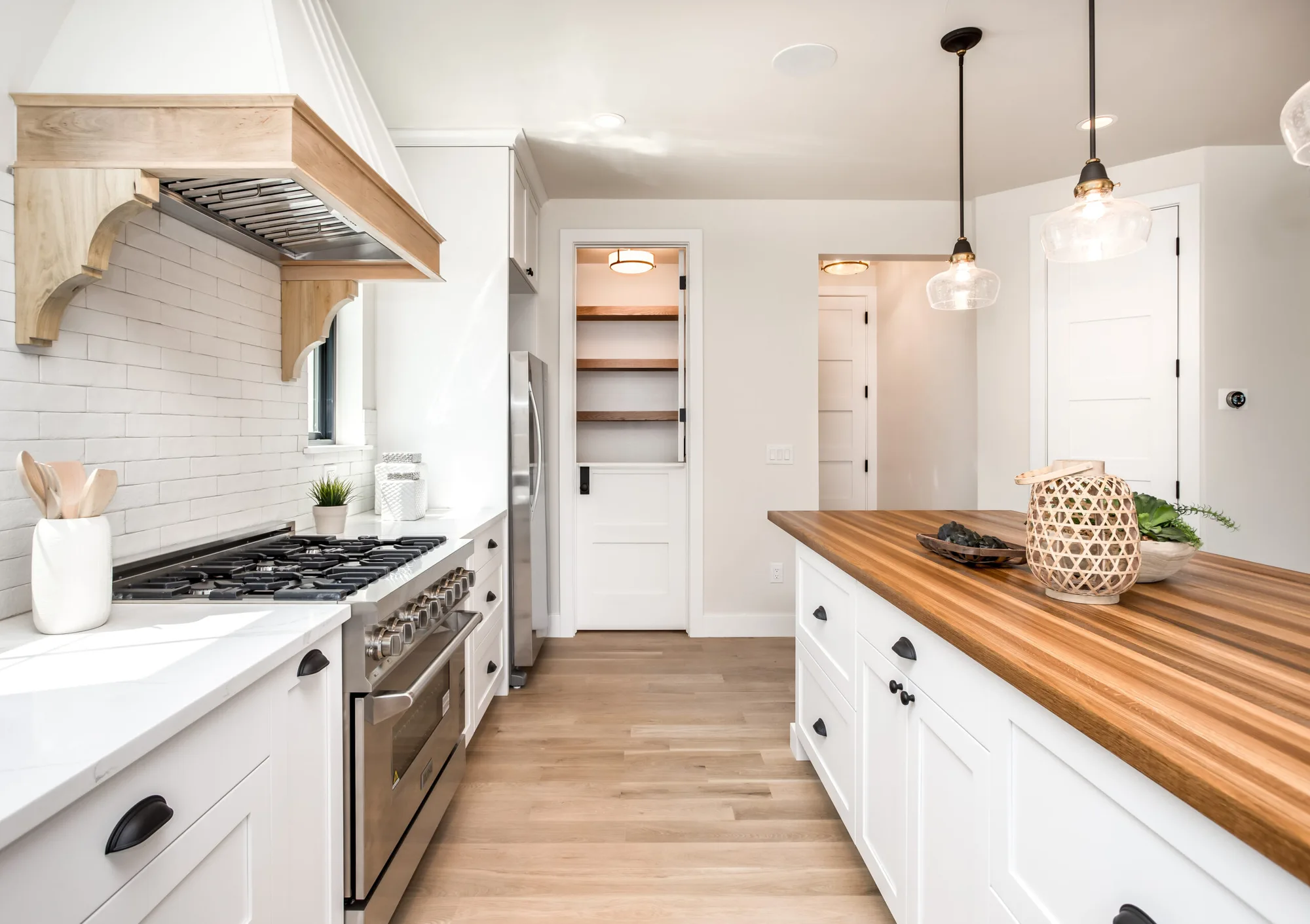 A-Frame range hood with wood corbels and a butcher block island