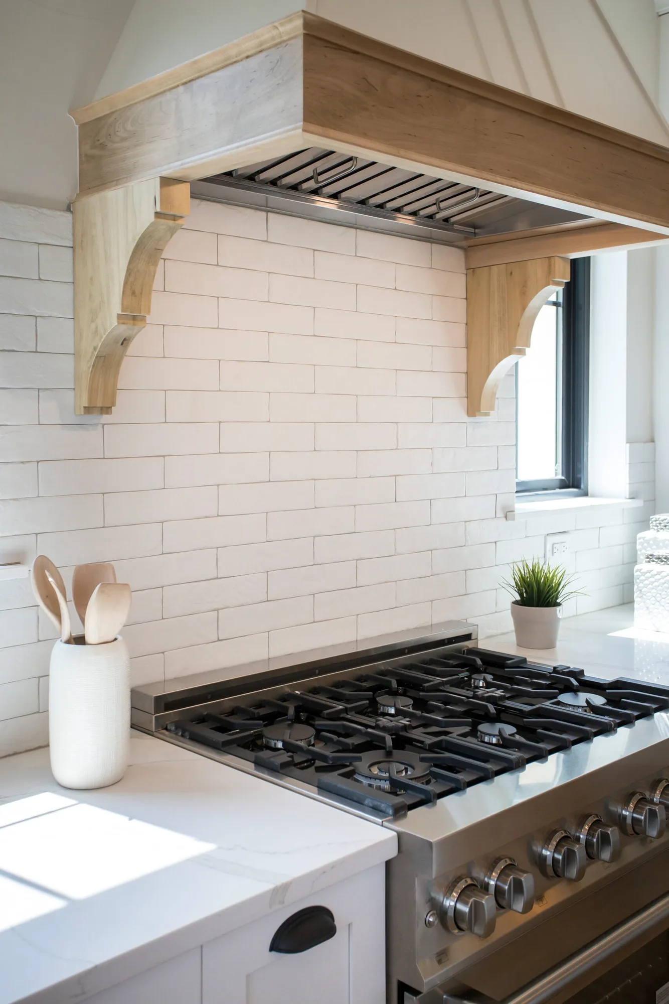 A-Frame range hood with solid wood corbels over subway tile